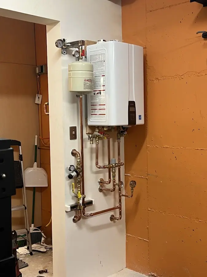 Plumbing technician inspecting water heater connections in Taylor